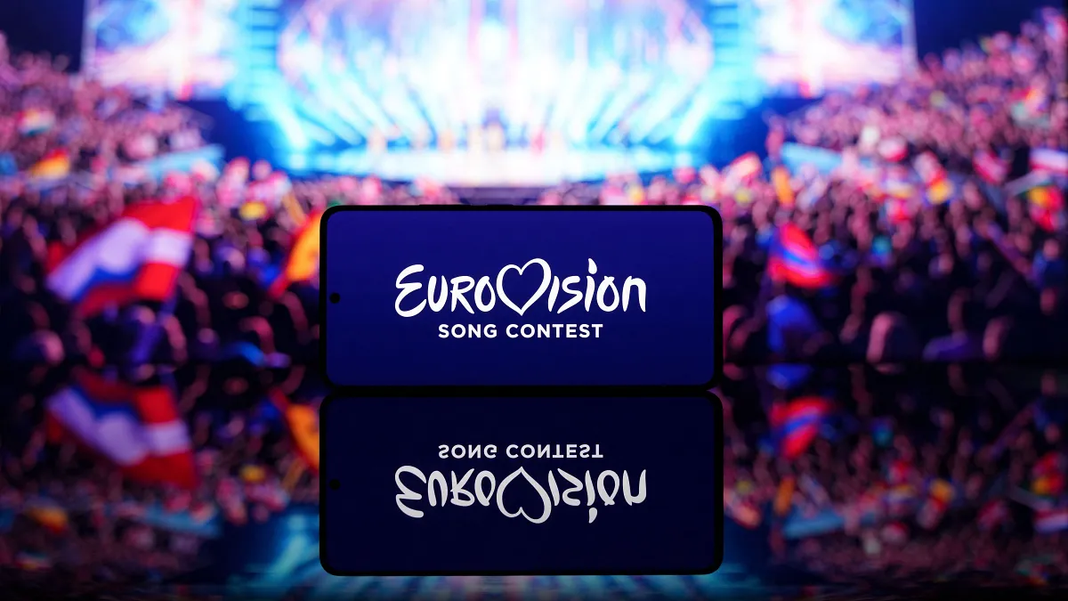 Smartphone mostrando el logo de Eurovision Song Contest con un escenario desenfocado de fondo